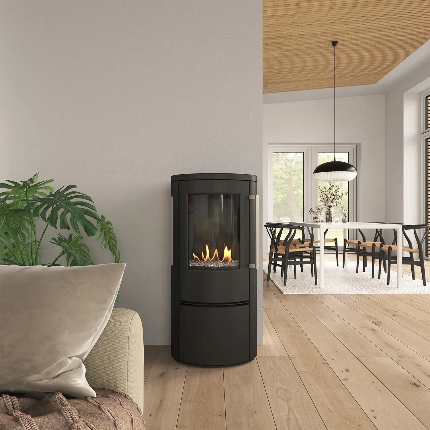 Sort indendørs bio pejs med flammer i, placeret i daglig stue ved siden af en plante og sofa.