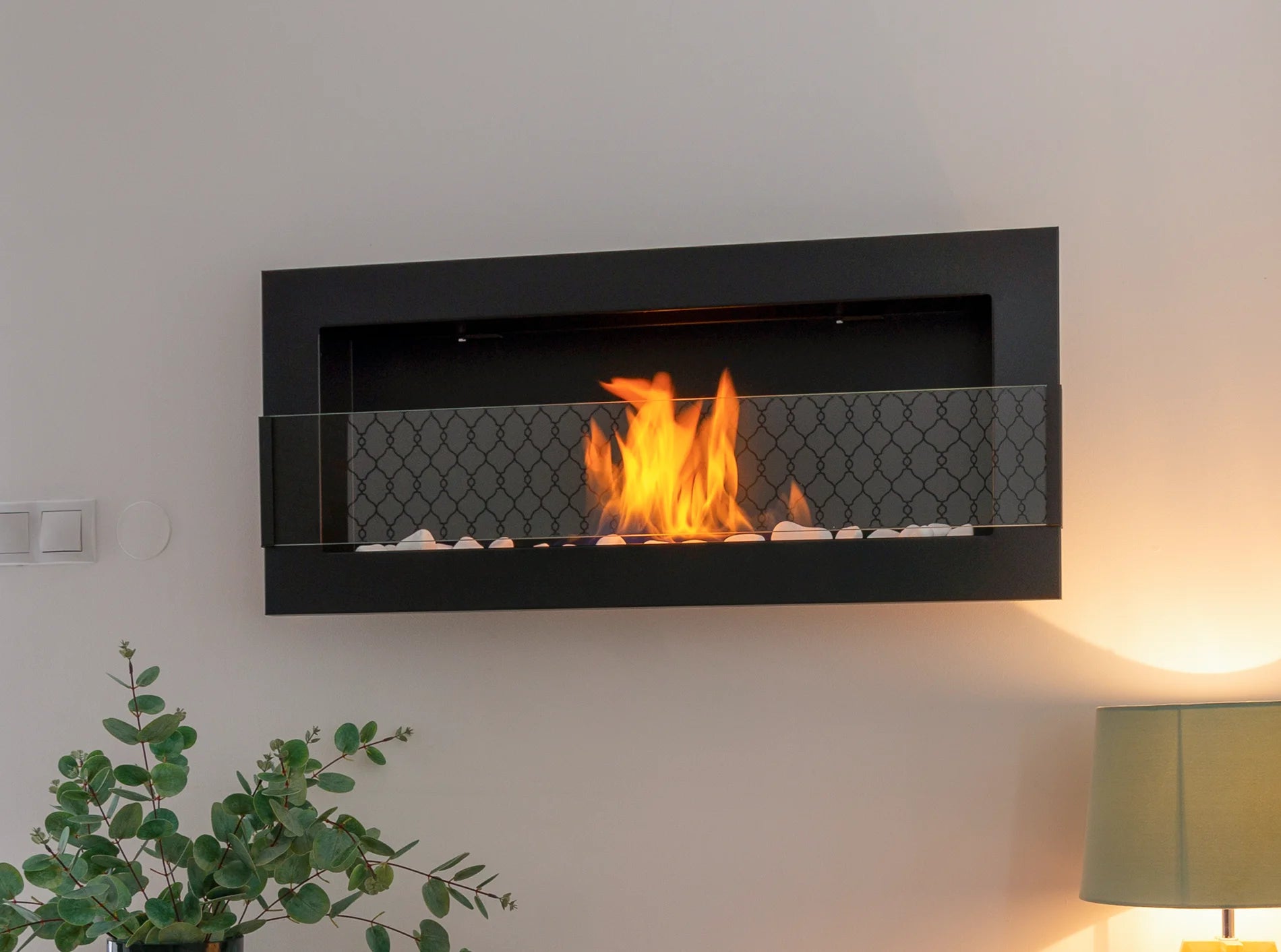sort vægmonteret biopejs med flammer og frontglas på stuevæg