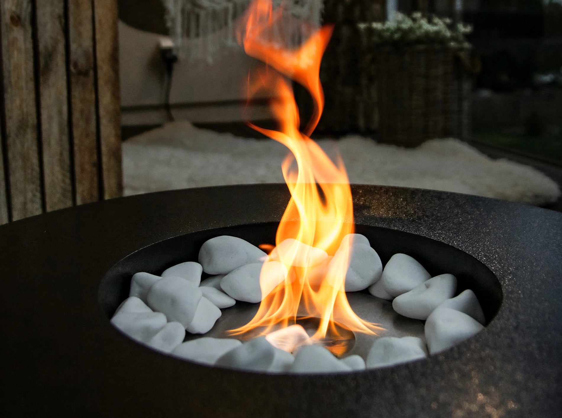 sort elipseformet udendørs biopejs med flotte flammer på terrasse