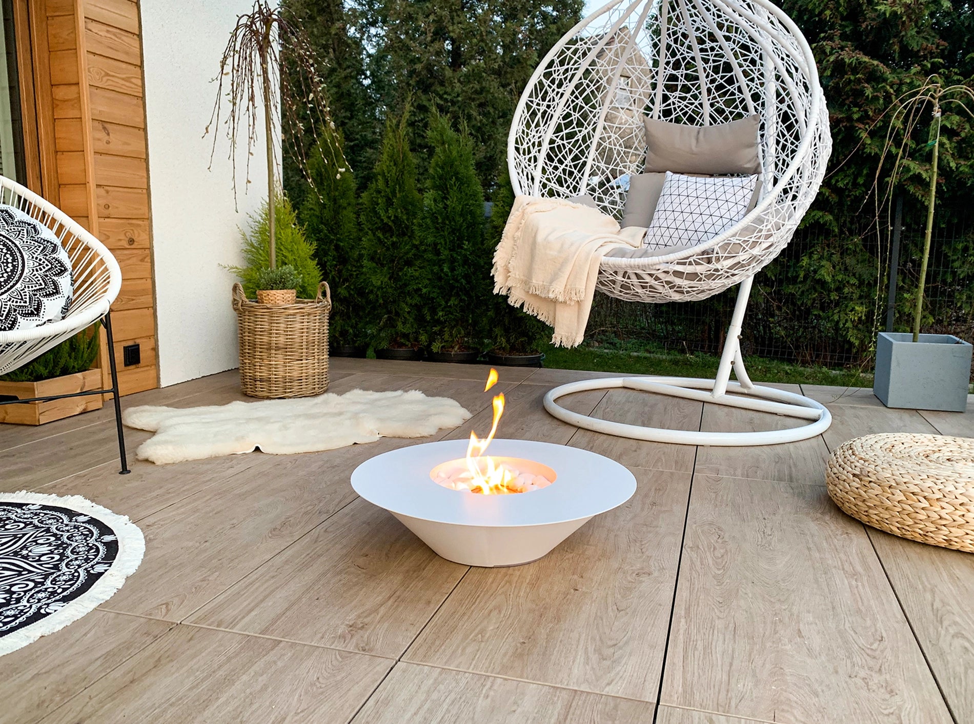 hvid elipseformet udendørs biopejs med flotte flammer på terrassegulv
