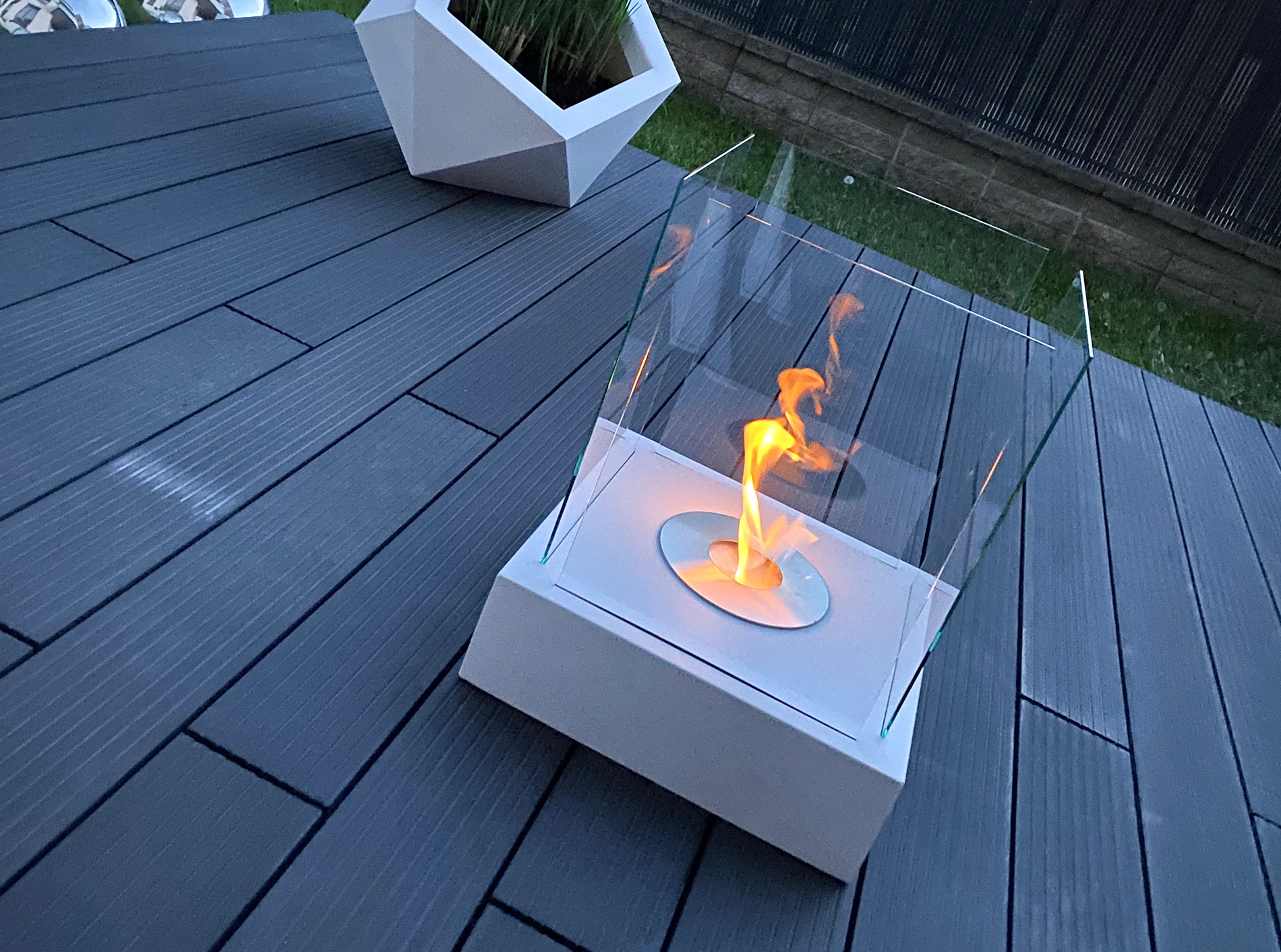 hvid bord biopejs med tændte flammer på terrassegulv