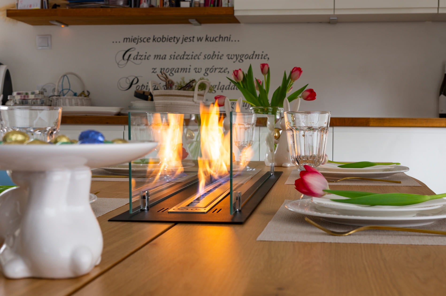 sort biopejs med sideglas indbygget i spisebord med tændte flammer