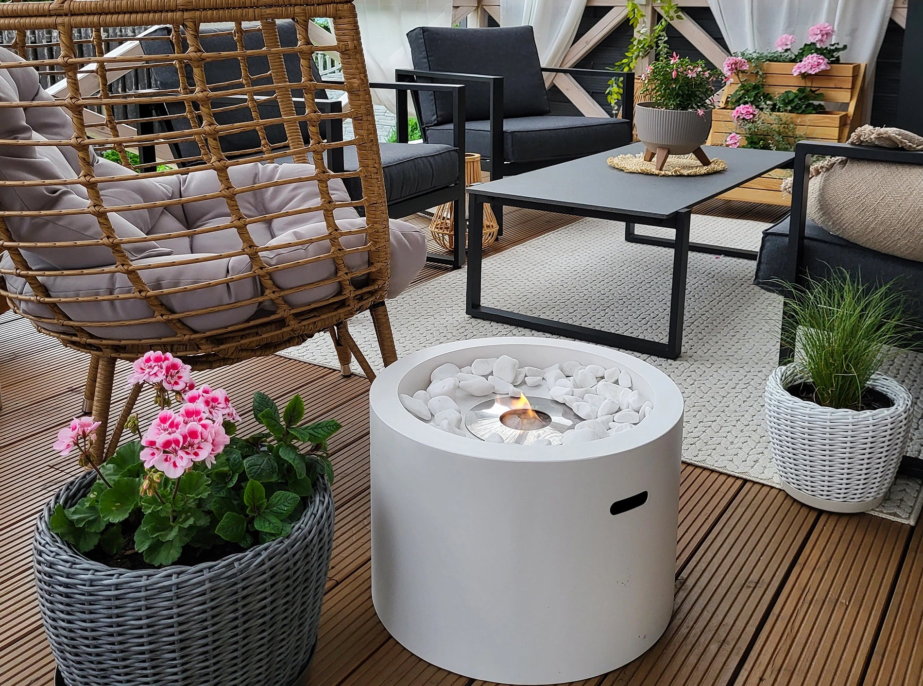fritstående hvid have biopejs med flotte flammer på brun terrasse