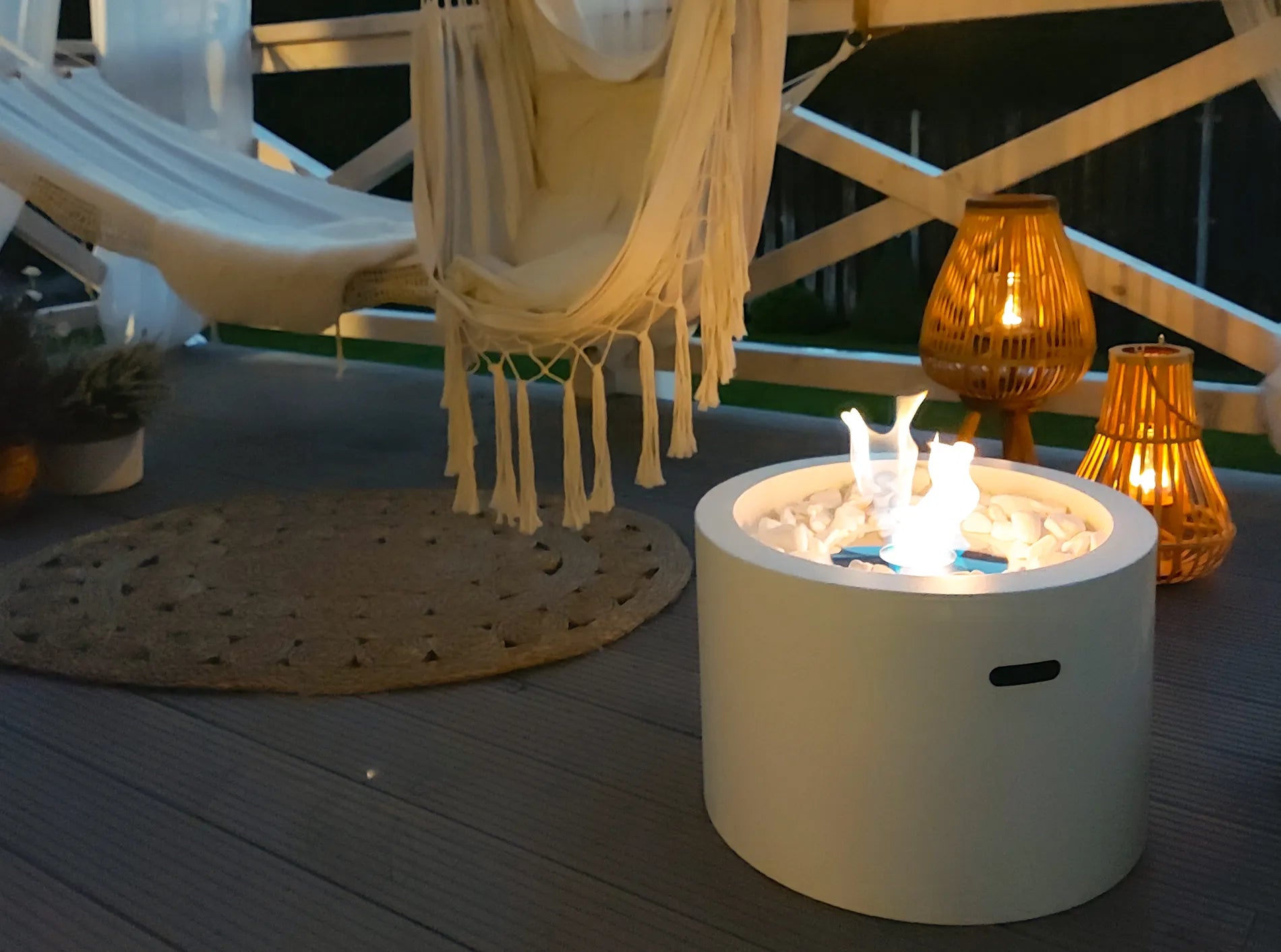 fritstående hvid have biopejs med flotte flammer på terrasse med hængekøje