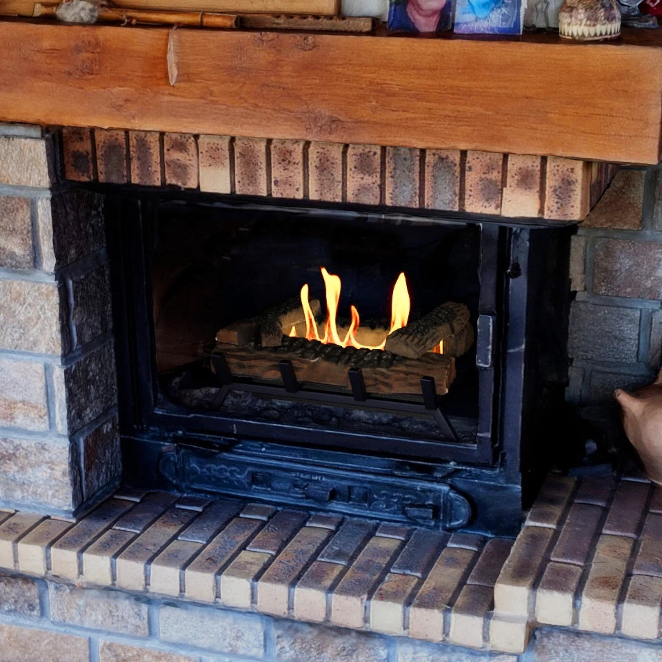 sort fritstående bålfad med keramiske brændestykker i flammer i en pejseindsats