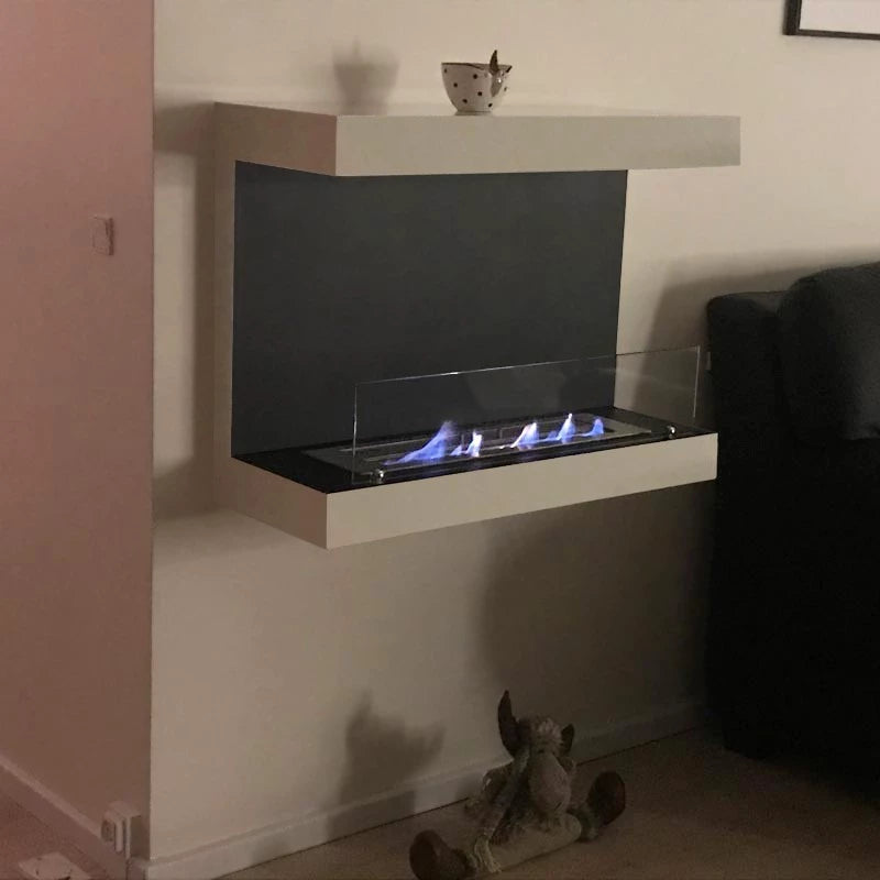 hvid tresidet væghængt biopejs med frontglas på stuevæg med tændte flammer